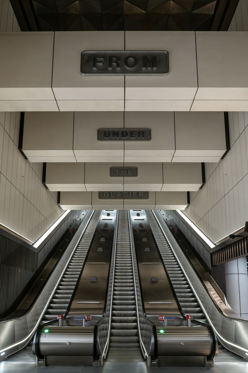 an escalator in a building with a sign above it