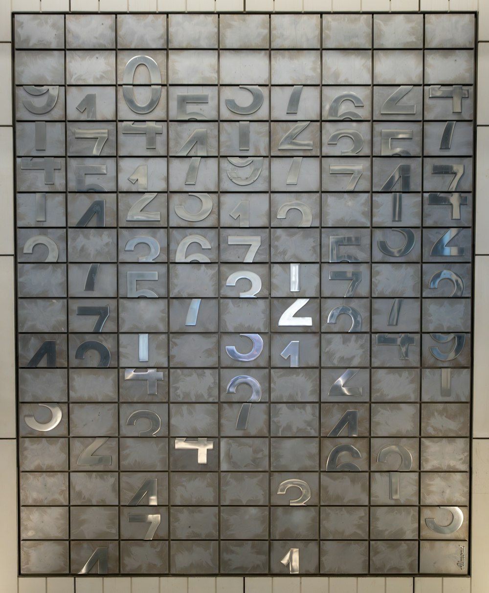 a tiled wall with letters and numbers on it