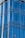 A series of reflective glass panels with a smooth, wavy design. The glass is tinted blue and features a dotted pattern across each panel, giving an impression of modern architecture.