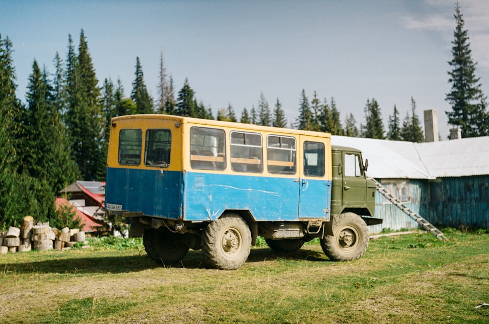 a blue and yellow truck parked in a field