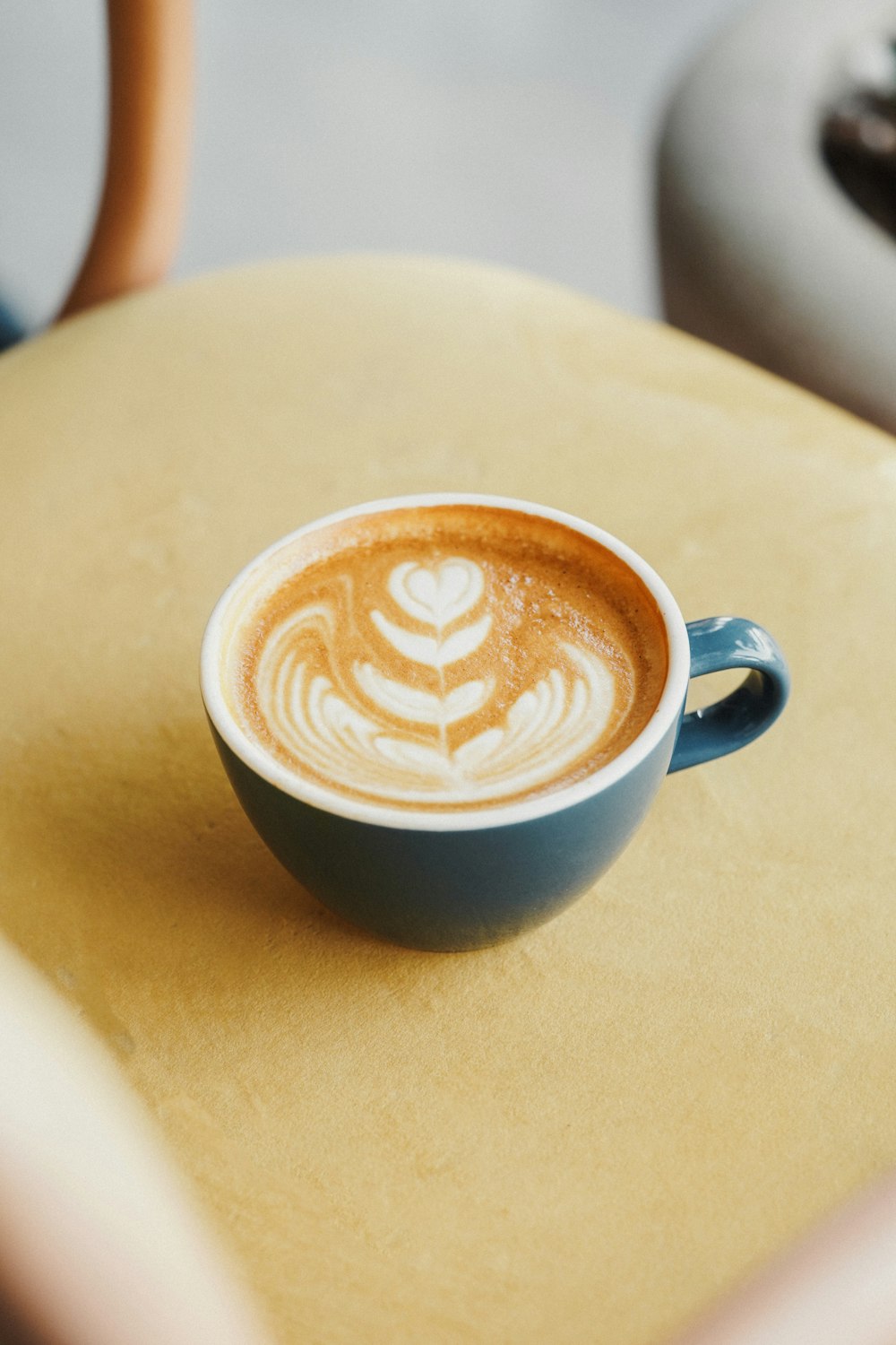 a cup of cappuccino sitting on top of a table