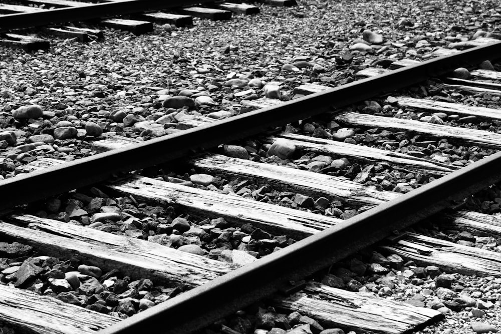 una foto in bianco e nero di un binario del treno