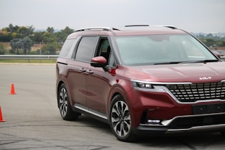 An instructor and student reviewing a lesson plan together beside a bright red training vehicle.