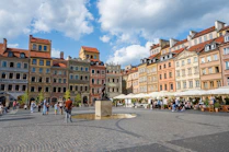 a group of people walking around a city square