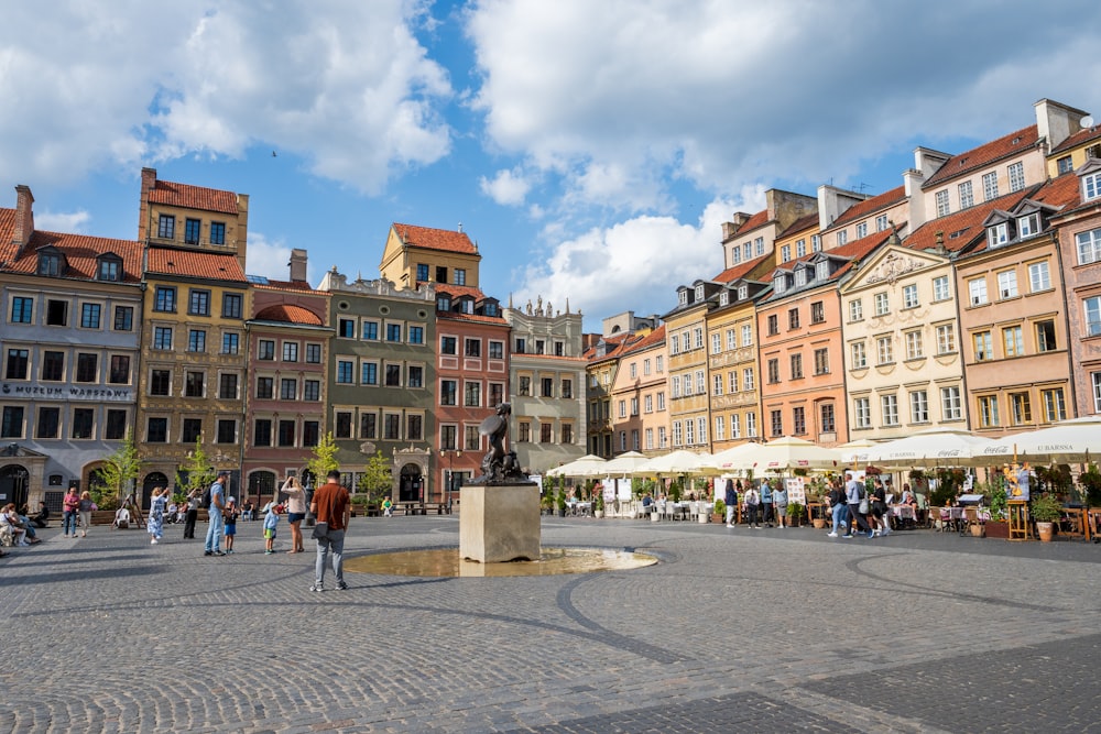 a group of people walking around a city square