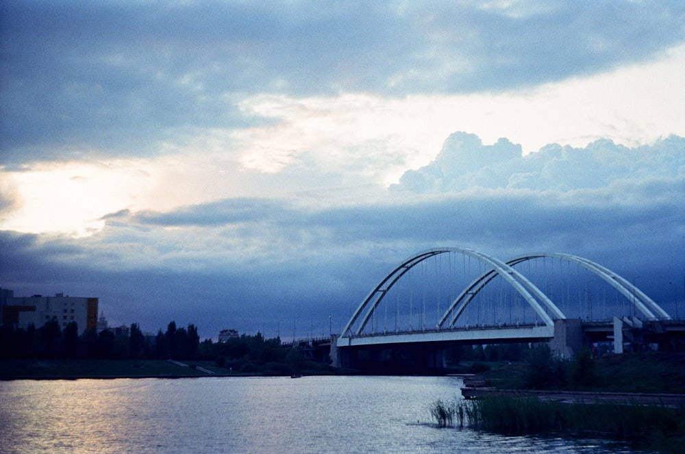 a bridge over a body of water under a cloudy sky