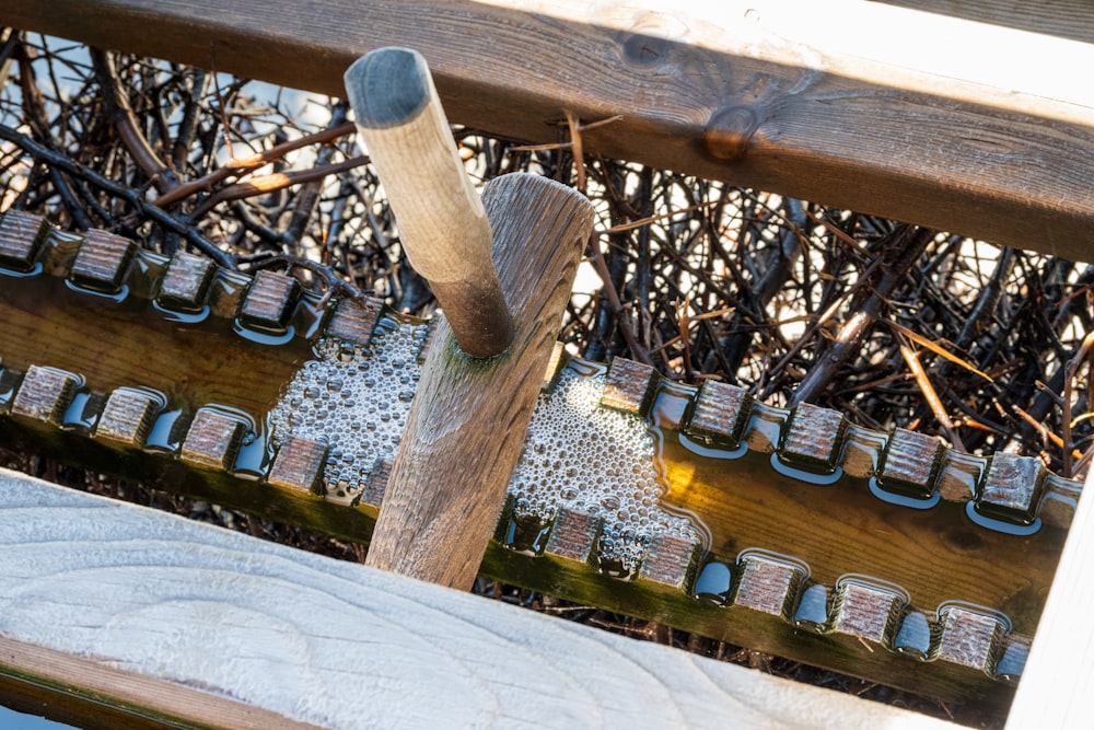 a close up of a wooden bench with many bottles of wine behind it