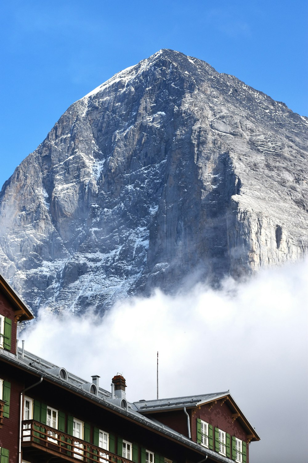 a large mountain is in the background behind a building