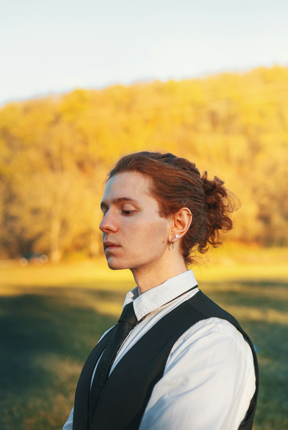 a woman with red hair wearing a black vest