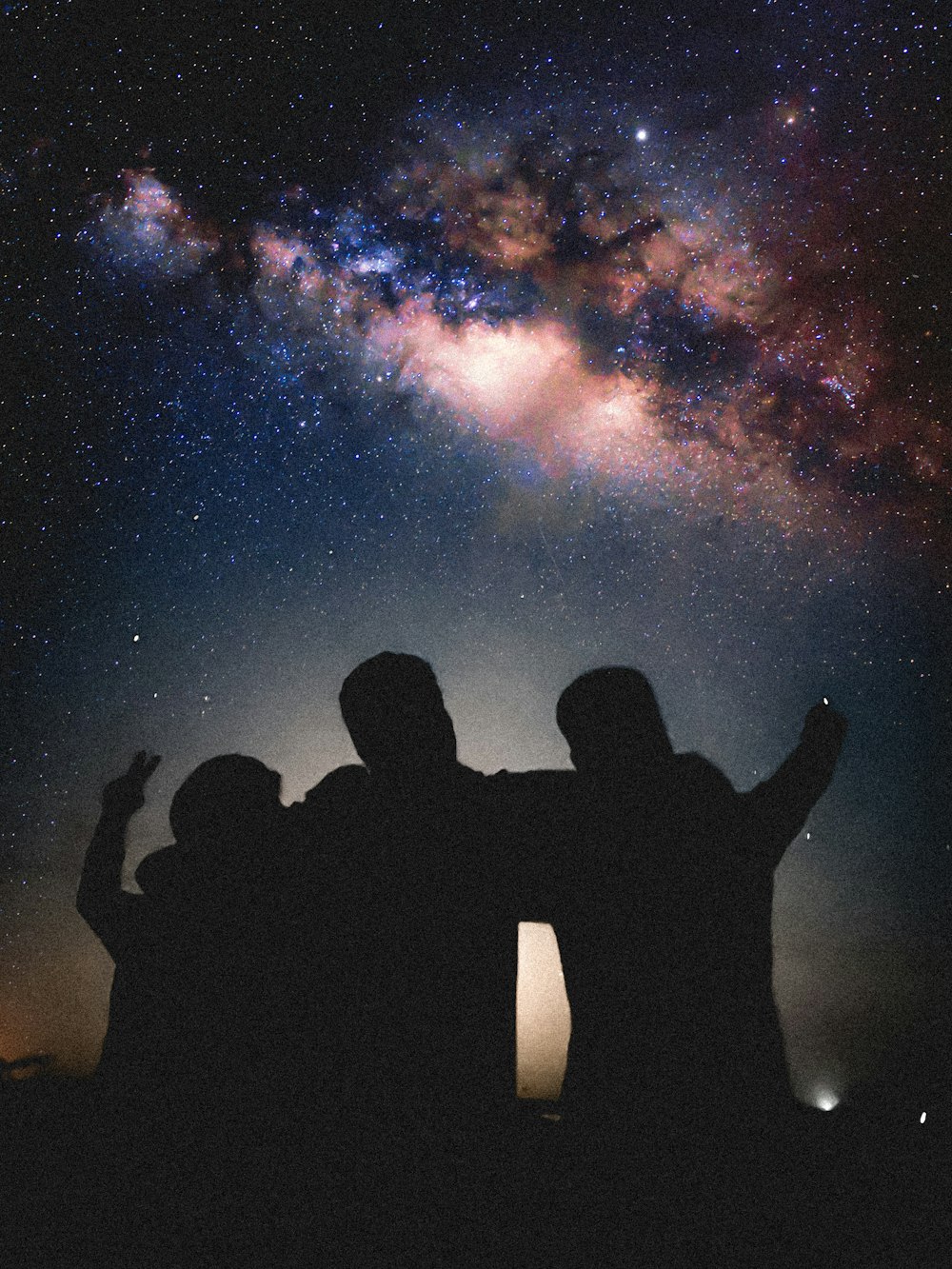 a group of people standing in front of a night sky
