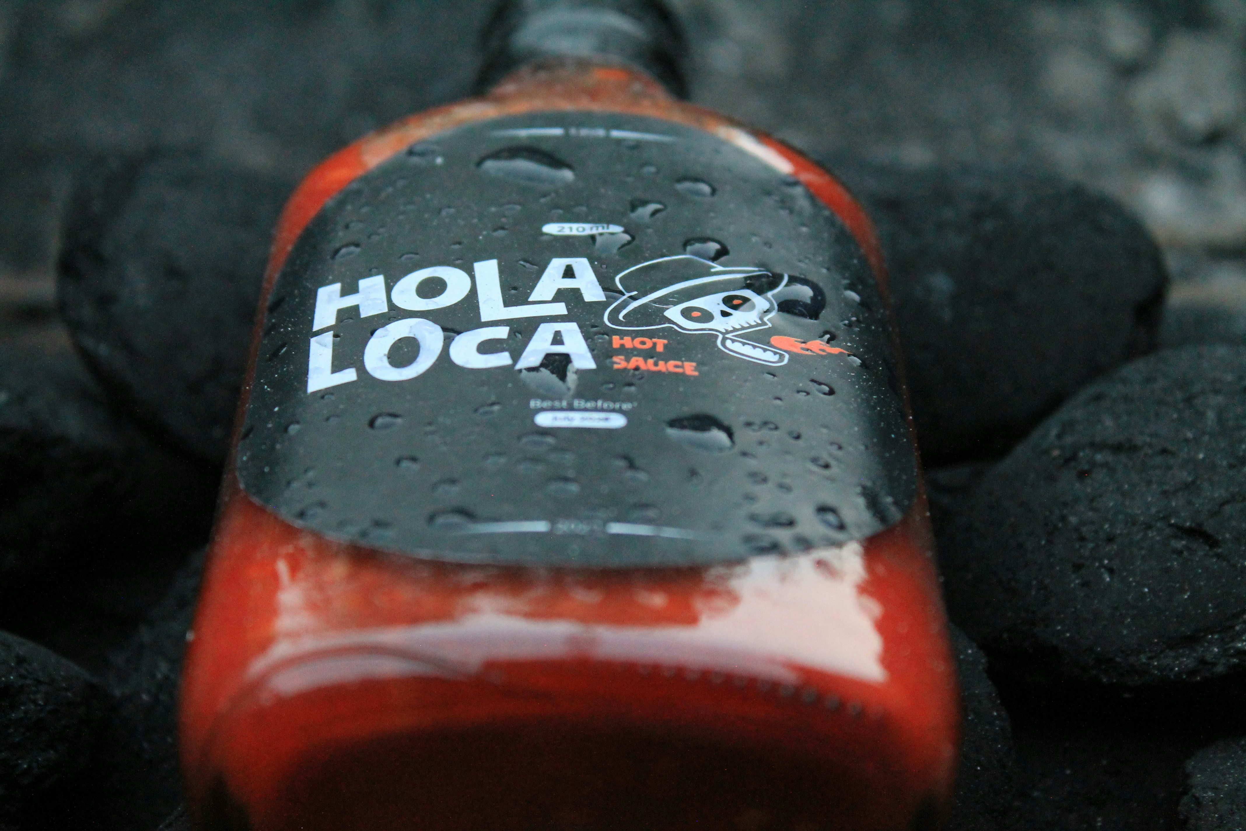 a close up of a bottle of soda on some rocks