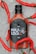 A bottle of hot sauce labeled 'Hola Loca' is surrounded by ice and red chili peppers, with the bottle covered in water droplets. The label features a stylized skull and indicates a best-before date of July 2026.