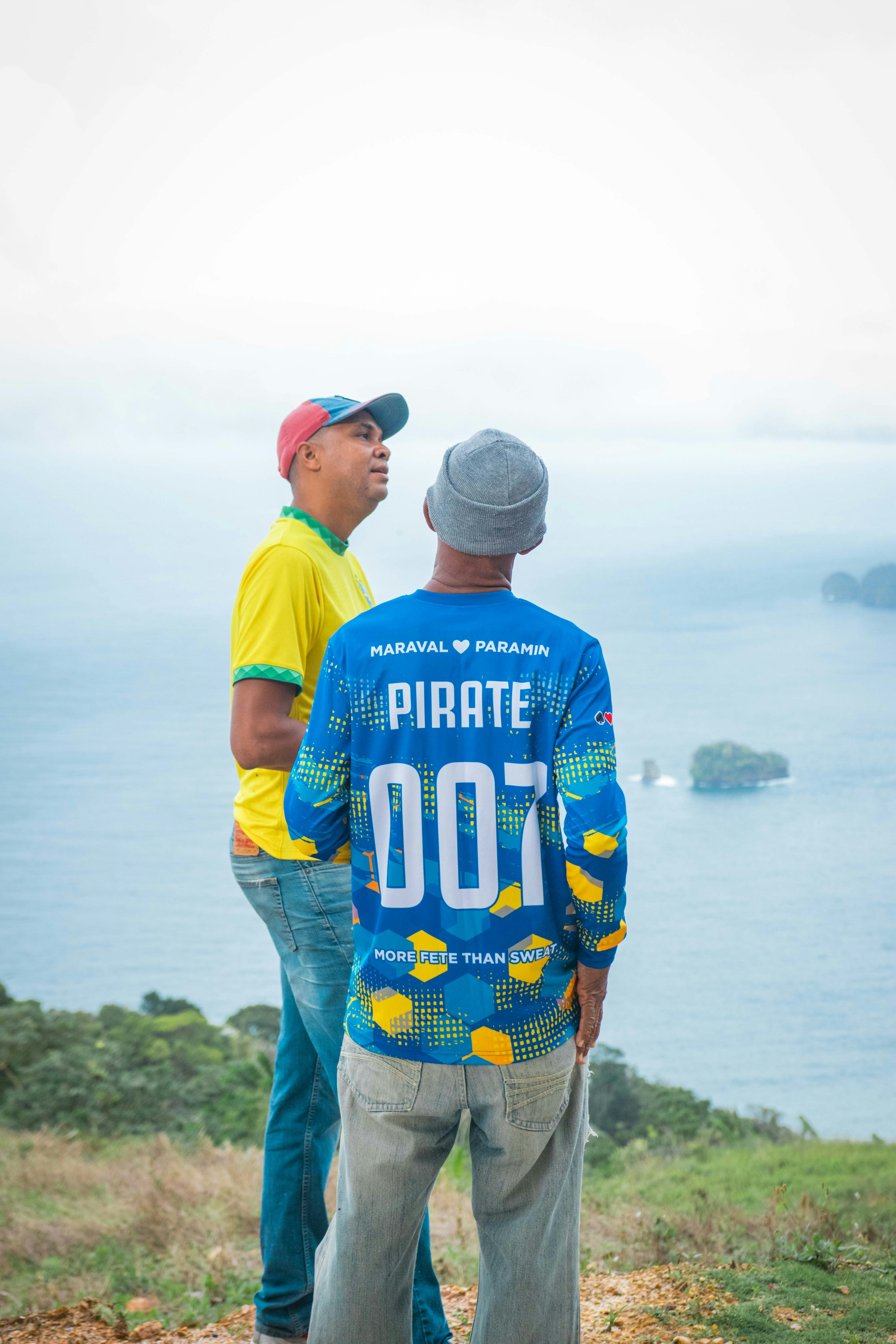 a couple of men standing on top of a lush green hillside