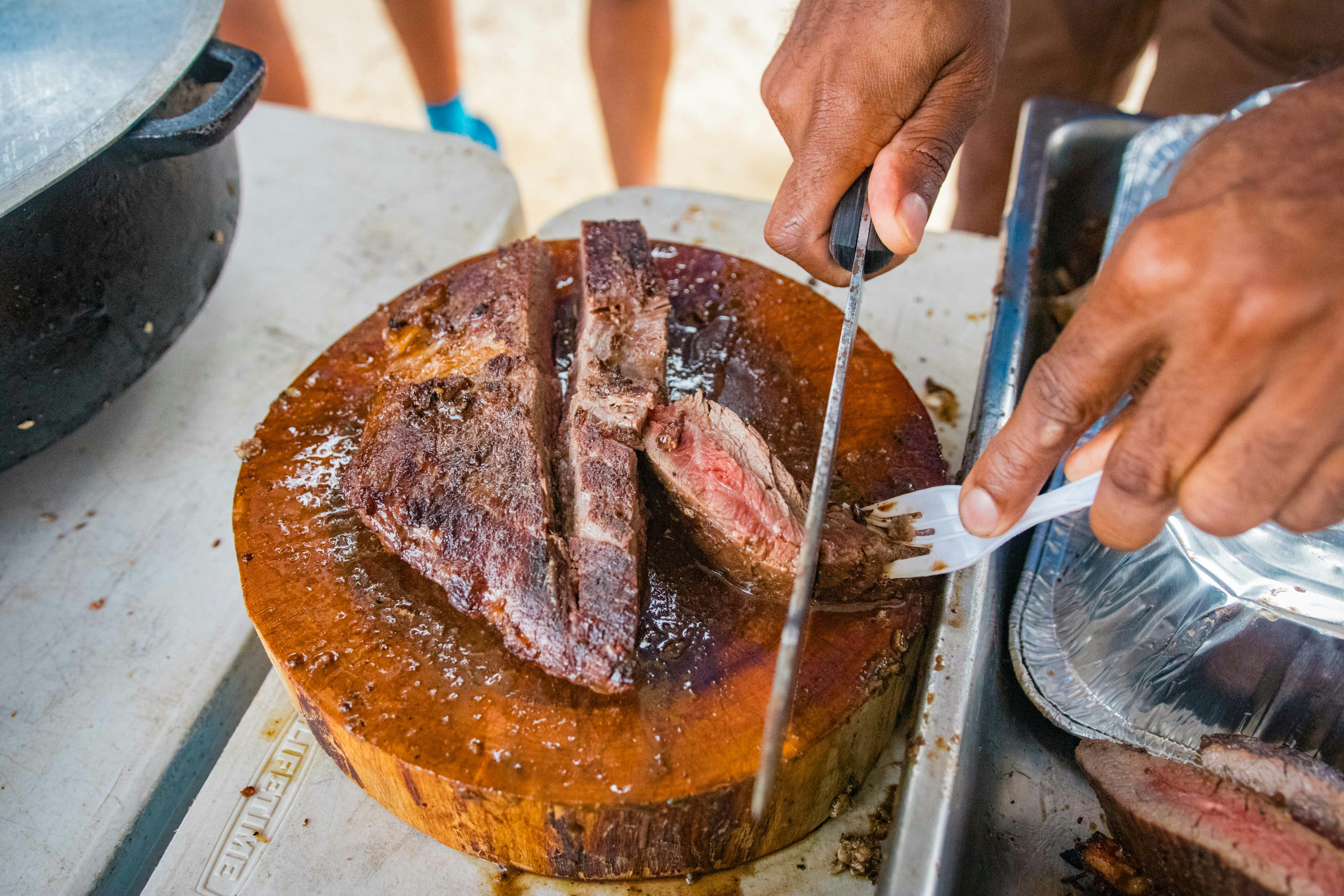 a person cutting a piece of meat with a knife