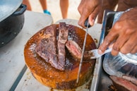 Butcher slicing a thick, juicy ribeye steak with precision and care.