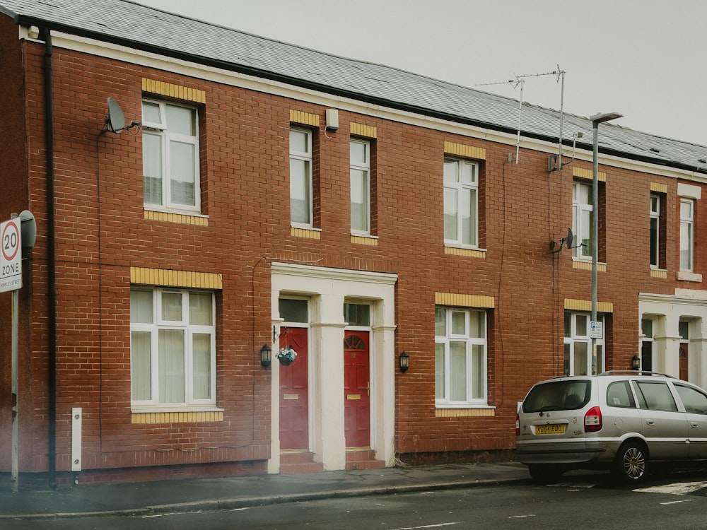 a car parked in front of a row of brick buildings