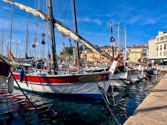 A vibrant coastal view of Essaouira with colorful boats docked at the harbor under a clear blue sky.