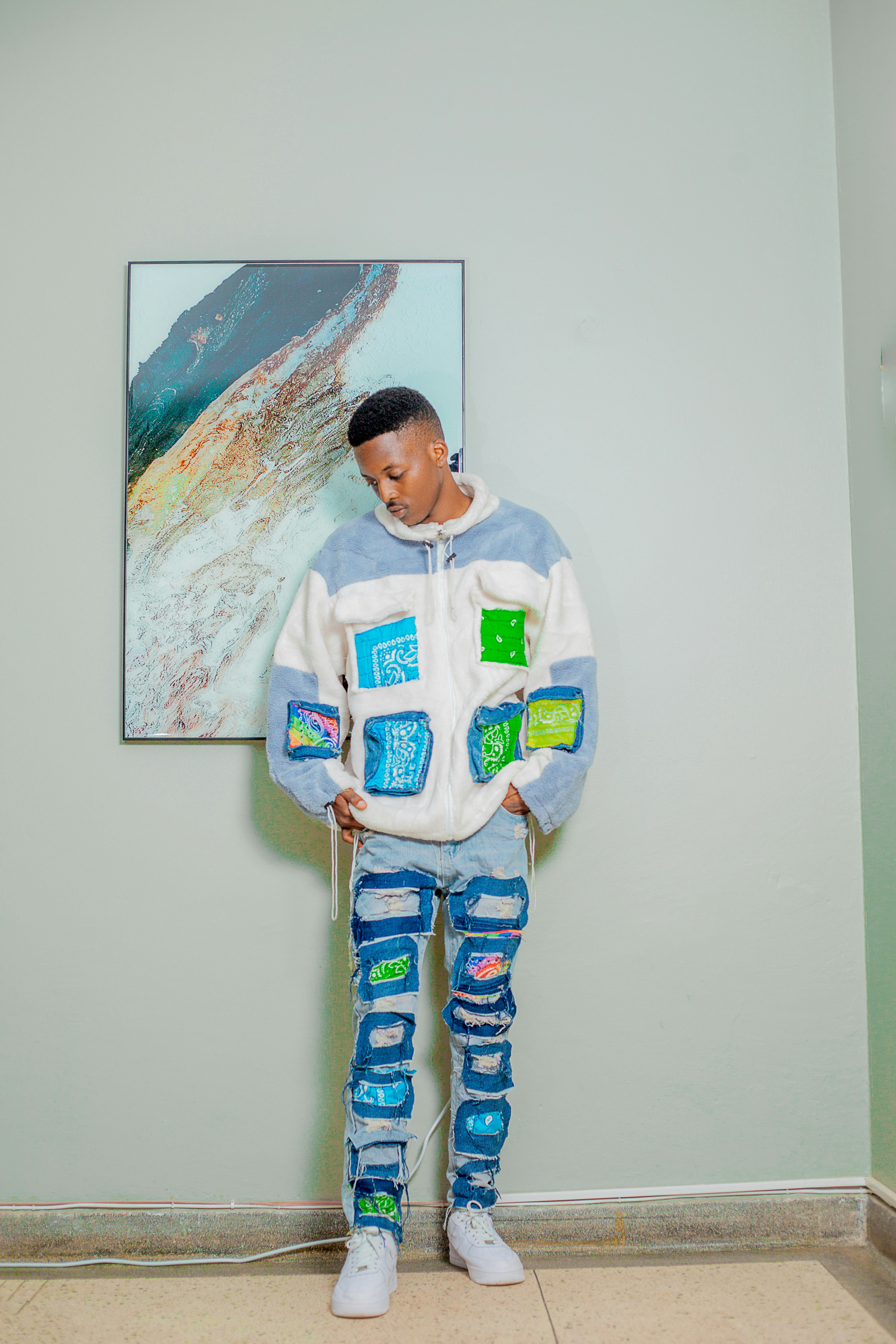 a young man standing in front of a painting