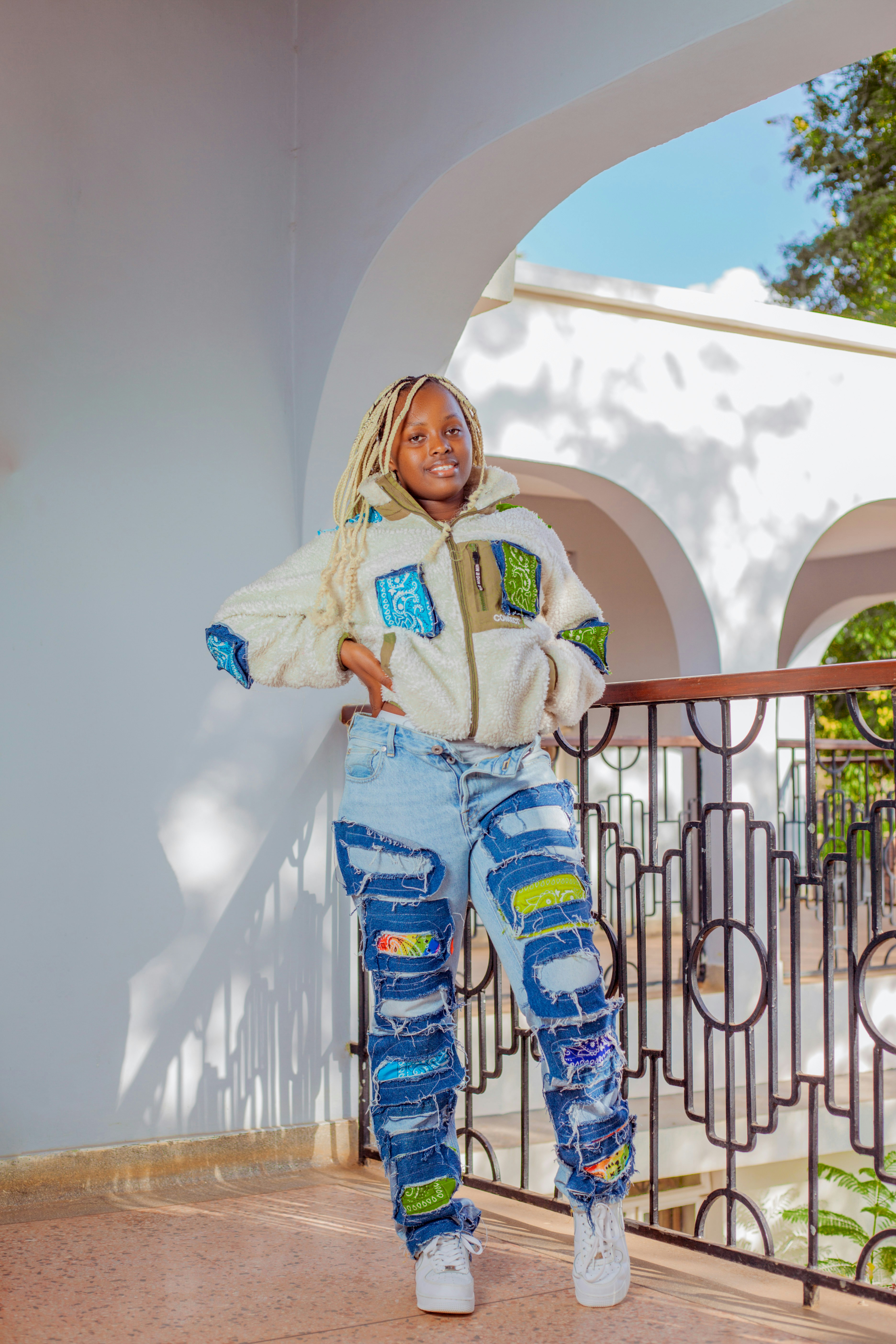 a young girl in ripped jeans and a white jacket