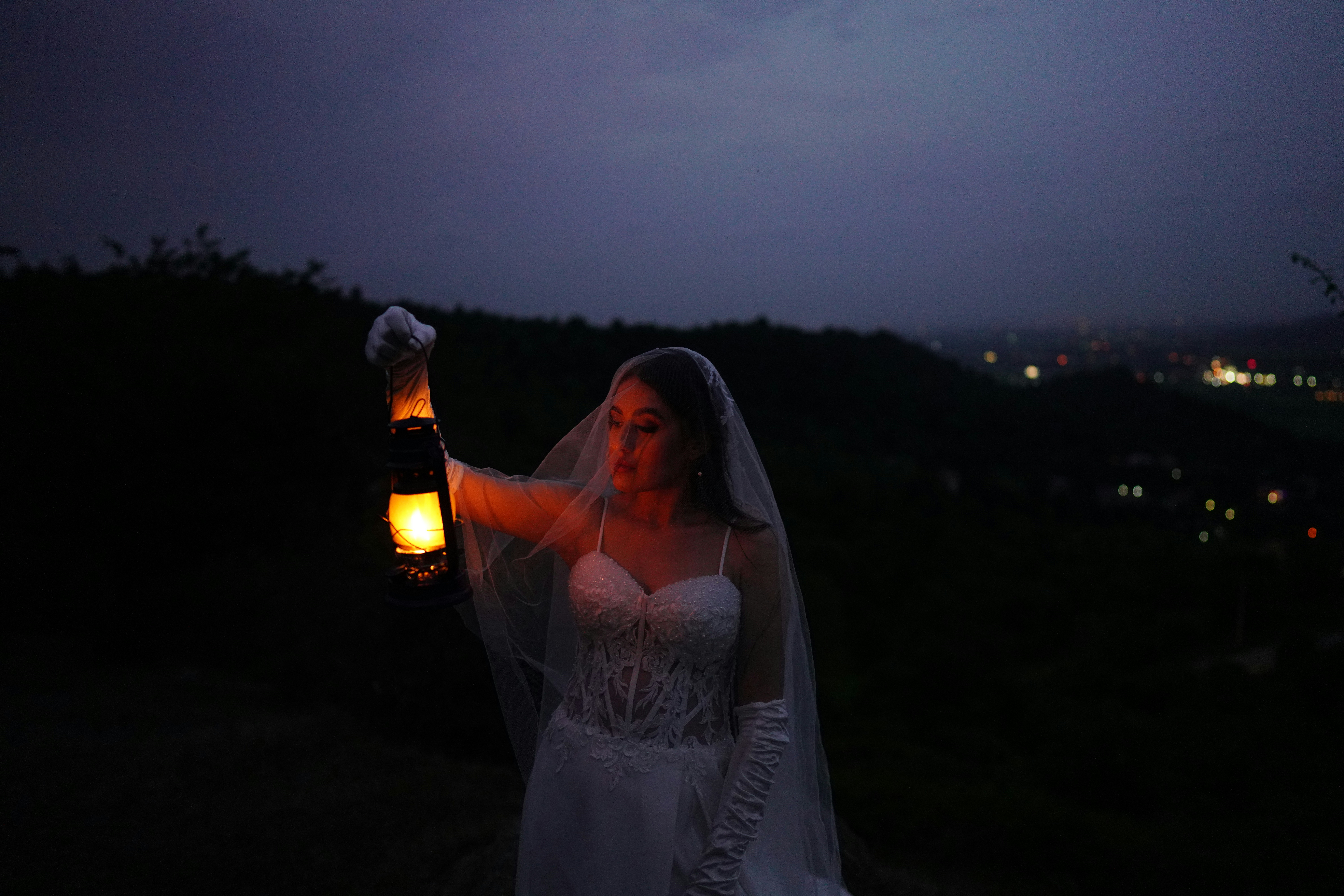 a woman in a wedding dress holding a lantern