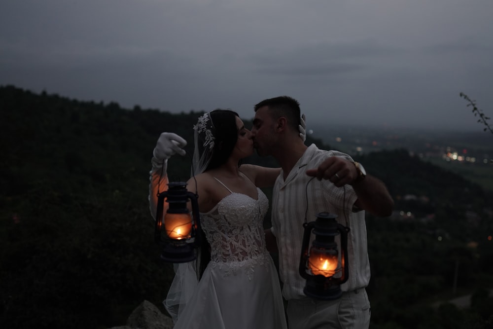 a bride and groom holding lanterns in their hands