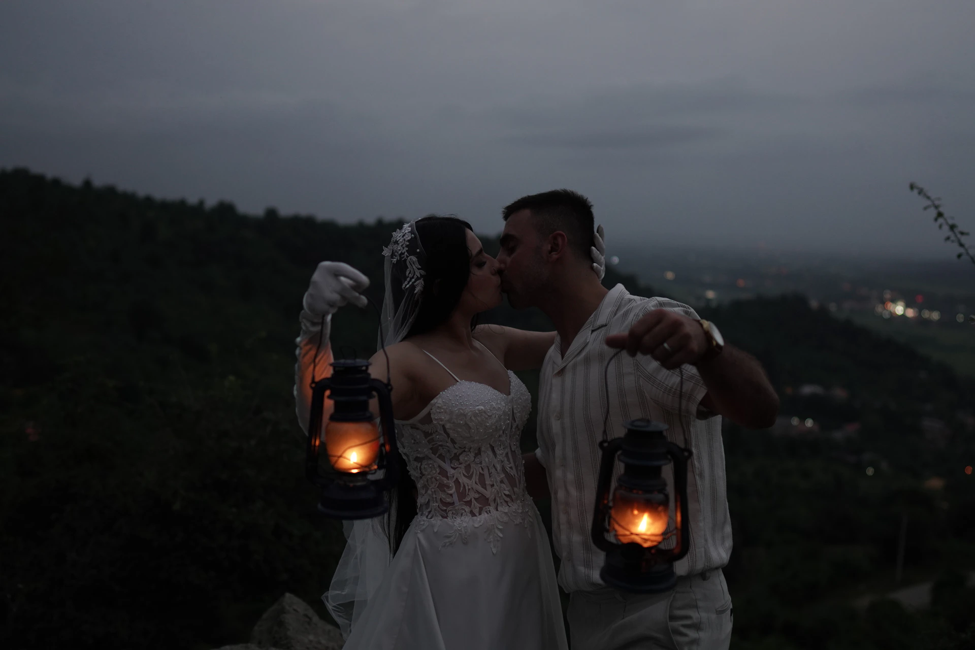 a bride and groom holding lanterns in their hands