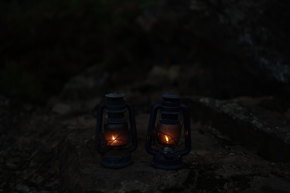 a couple of lanterns sitting on top of a rock
