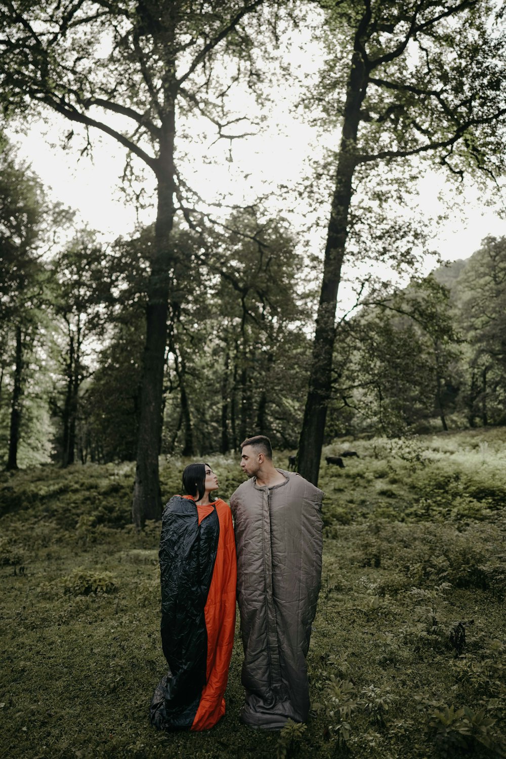 a couple of people standing in a forest