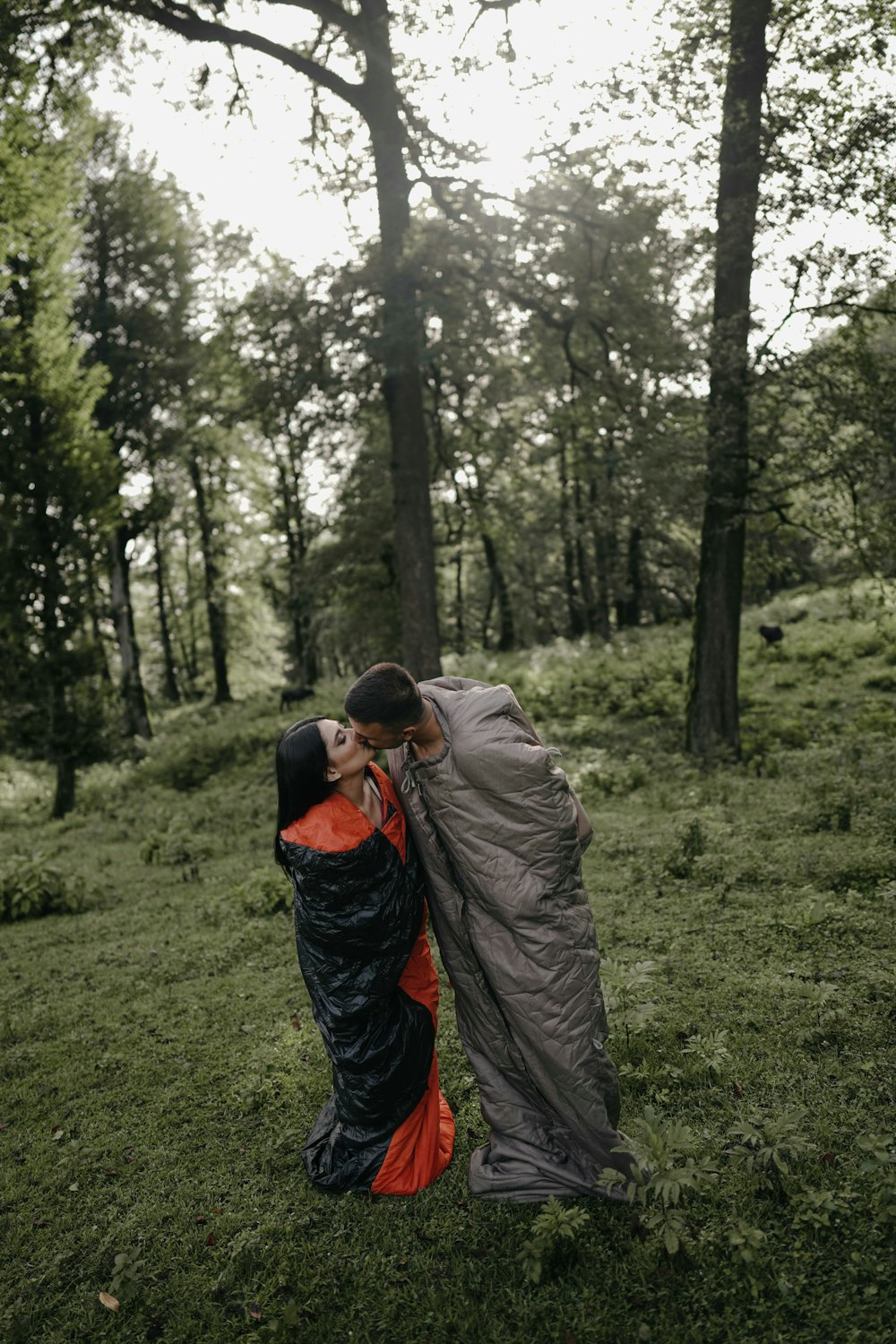 a man and woman kissing in the woods