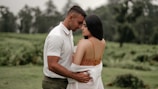 Couple embracing in a lush outdoor setting during their pre-wedding shoot.