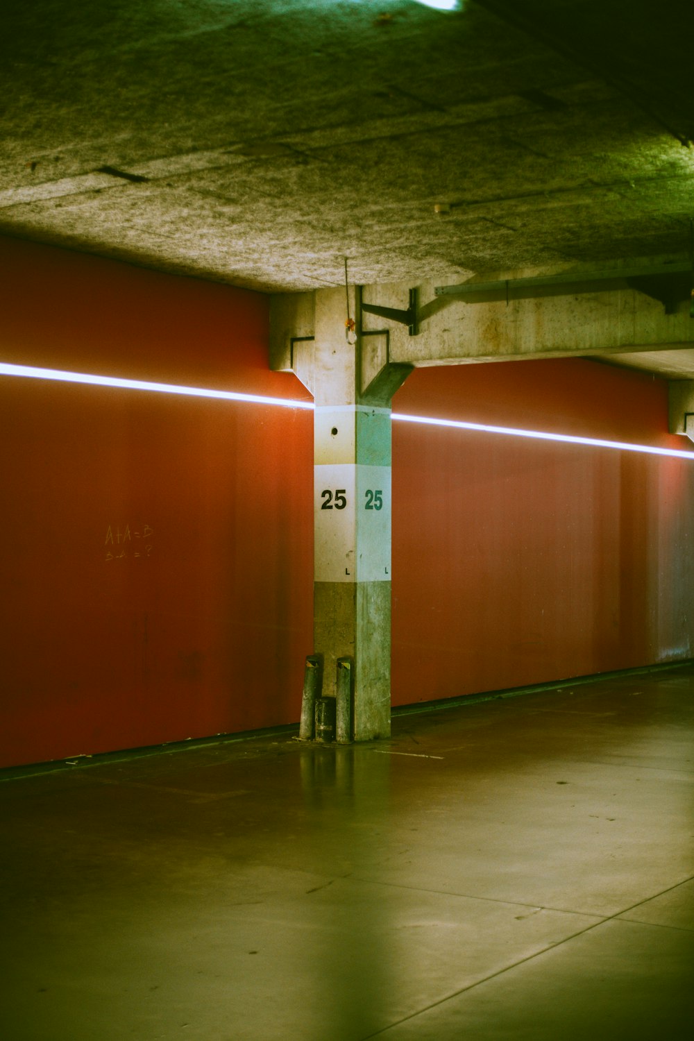 a parking garage with red walls and a clock