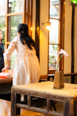 A candid moment of a stylist gently arranging decor at an intimate celebration in warm natural light.