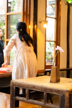 A candid moment of a stylist gently arranging decor at an intimate celebration in warm natural light.