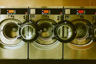 a row of washers in front of a row of dryers