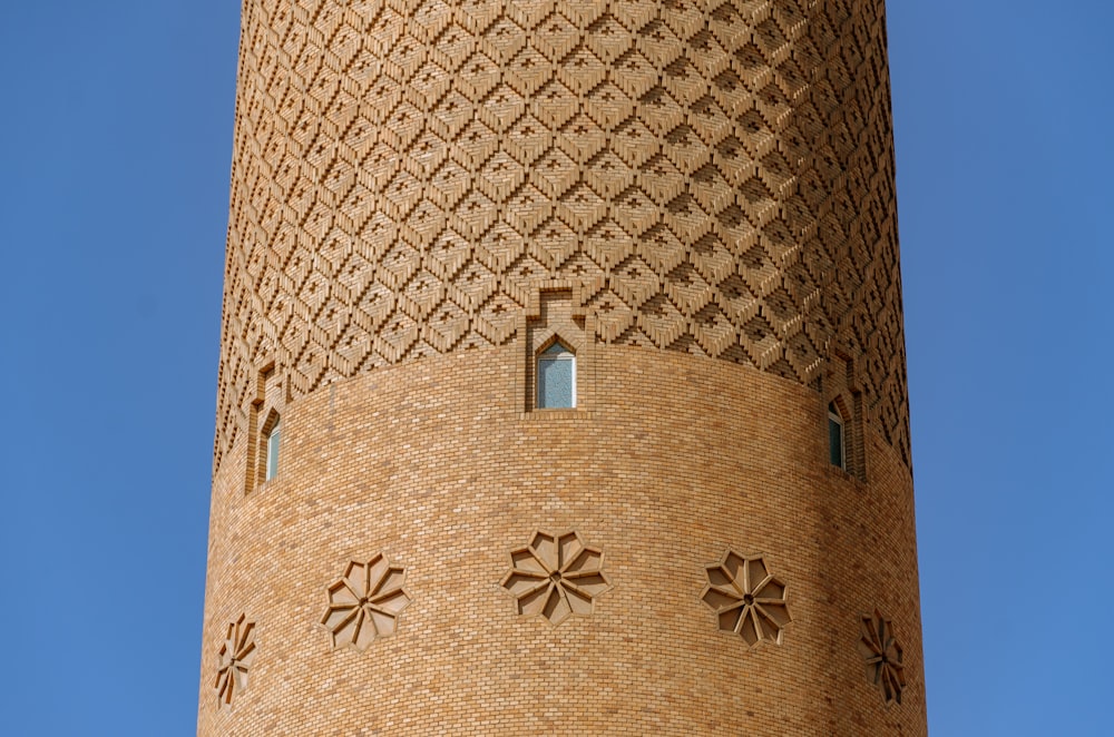 une haute tour en brique avec une horloge sur le côté