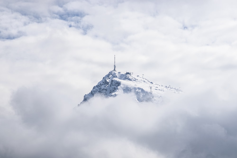 a mountain covered in clouds with a radio tower on top