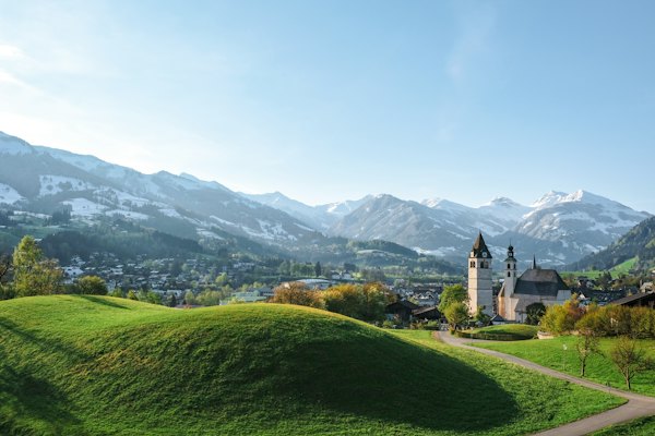 A church in the middle of a lush green field — Kitzbühel, Austria