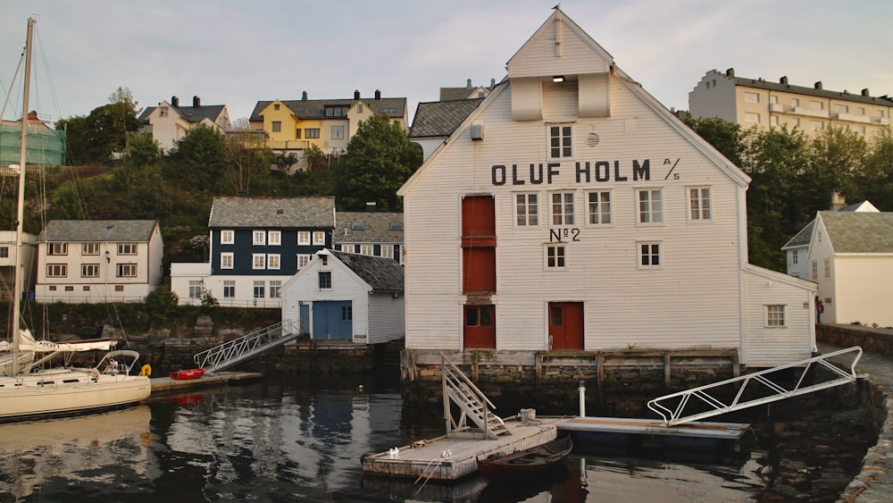 a white building sitting next to a harbor filled with boats