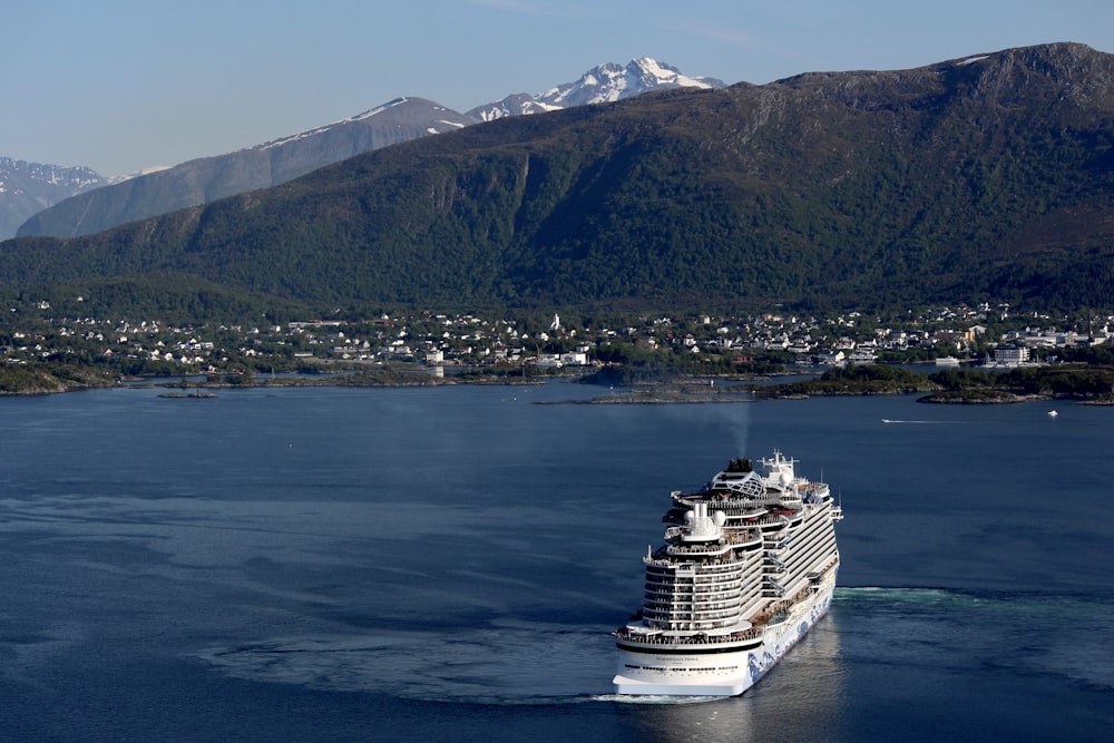 a cruise ship in the water with mountains in the background