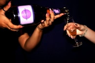 A close-up of a champagne bottle being poured into a flute, sparkling under soft lighting.