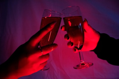 Close-up of hands holding sparkling champagne glasses with $happy coin logos
