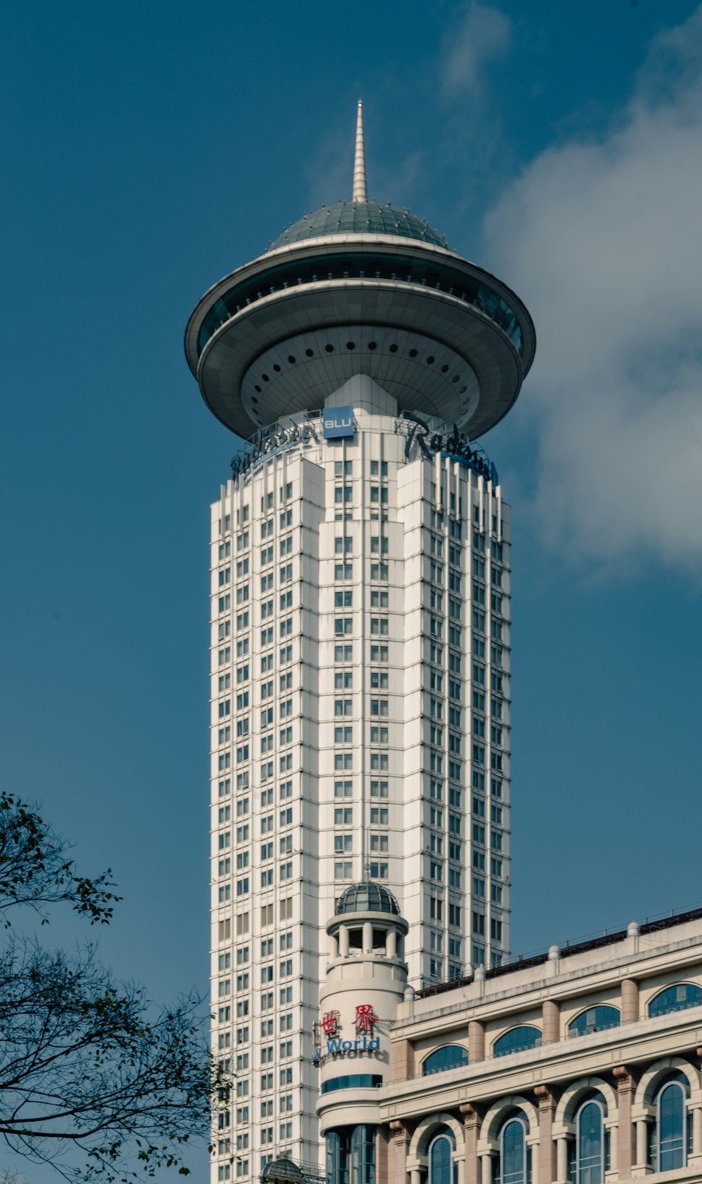 a tall white building with a sky scraper in the background