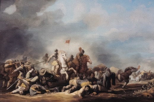 A historical battle scene with numerous soldiers engaged in combat. Some soldiers are on horseback, with one prominently placed white horse in the center. Soldiers on foot are wielding spears and swords. The sky is cloudy with smoke, suggesting the chaos and intensity of the battle. There are injured or fallen soldiers on the ground, highlighting the brutality of the conflict.