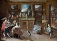 A lavishly decorated room filled with numerous paintings, sculptures, and artifacts. Several individuals are present, seemingly engaged in an art discussion. A prominently dressed man holds up a painting for others to view. A child in period costume carries another piece of artwork. The walls are adorned with framed artworks, and a table is draped with a cloth, supporting several art pieces. A parrot stands on the floor, adding to the opulent atmosphere.