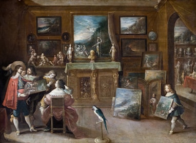 A lavishly decorated room filled with numerous paintings, sculptures, and artifacts. Several individuals are present, seemingly engaged in an art discussion. A prominently dressed man holds up a painting for others to view. A child in period costume carries another piece of artwork. The walls are adorned with framed artworks, and a table is draped with a cloth, supporting several art pieces. A parrot stands on the floor, adding to the opulent atmosphere.