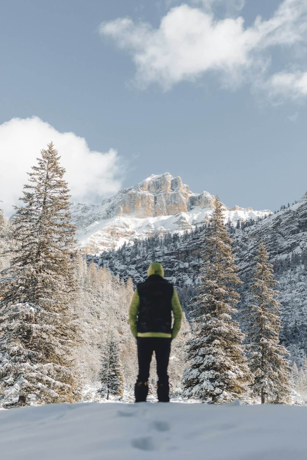 Un hombre de pie en la cima de una ladera cubierta de nieve