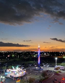 A vibrant photo of families enjoying colorful rides at Luwisadeng Wonderland during sunset.