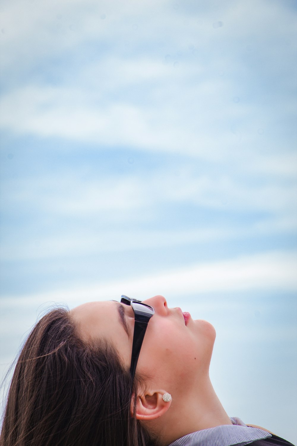 a woman with her eyes closed looking up into the sky