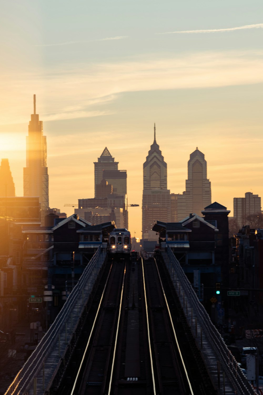 a train traveling over a bridge with a city in the background