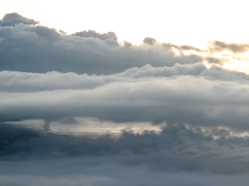 un aereo che vola nel cielo con un sacco di nuvole